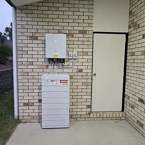Inverter mounted above a stacked battery unit on the brick wall of a Queensland home