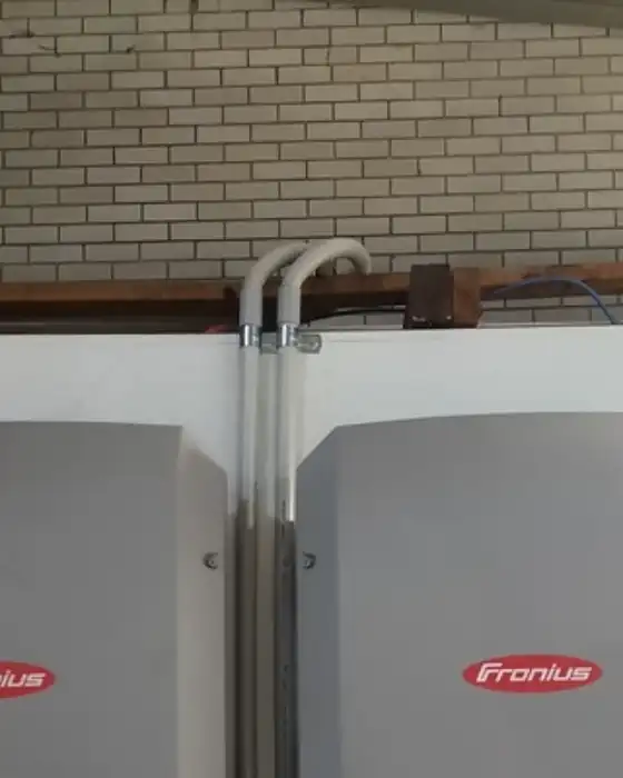 Two Fronius Symo inverters mounted on a brick wall