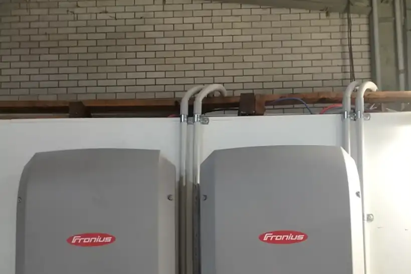 Two Fronius Symo inverters mounted on a brick wall